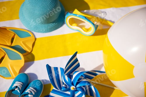 Preview: Beach accessories on yellow striped towel