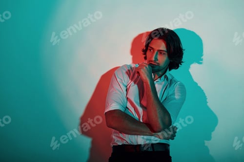 Preview: Portrait of young stylish man that stands in neon lights in the studio
