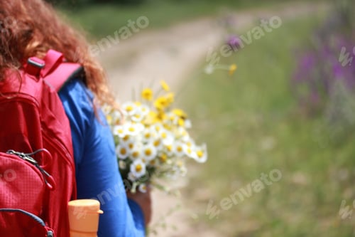 Preview: Girl walking in nature.Flowers in hand. In beautiful nature.