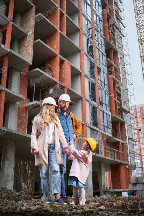Preview: Happy family standing at construction site.