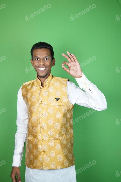 Preview: Indian boy showing OK and smiling on the green background