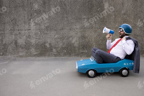 Preview: Funny businessman driving retro pedal car outdoor