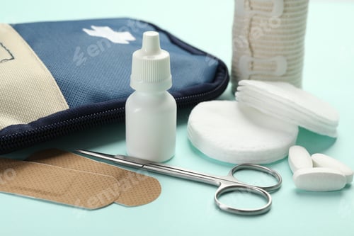 Preview: First aid kit. Different medical supplies on light blue background, closeup