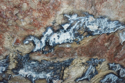 Preview: Dark brown colored rock featuring intricate black patterns on its surface in a cave