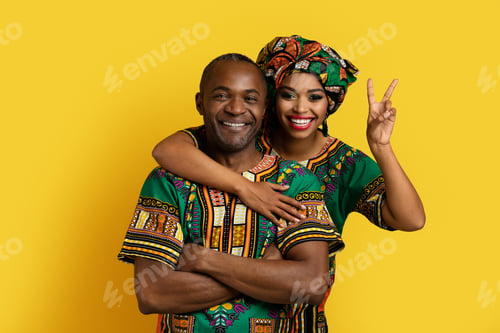 Preview: Portrait of cheerful black spouses posing on yellow