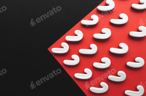 Preview: A lot of gingerbread candy cane shaped cookies on a red background.