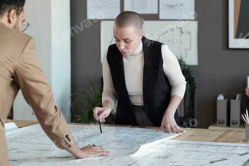 Preview: Confident businesswoman bending over table with blueprint