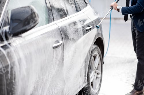 Preview: Businessman washing his car
