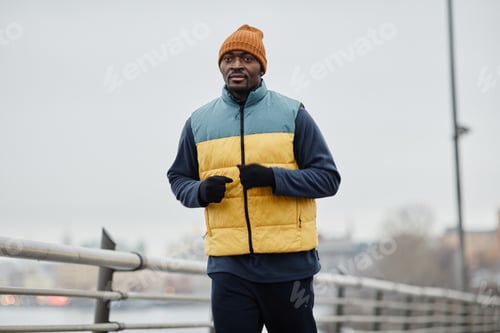 Preview: Young African American sportsman in activewear jogging outdoors in the morning