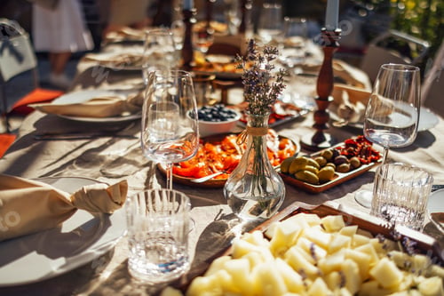 Preview: hairs and a table for guests, decorated with candles, are served with cutlery and crockery