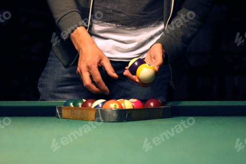 Preview: Hands holding billiard balls with alight on, dark background