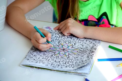 Preview: Close-up of girls hands draw with crayons in antistress coloring.