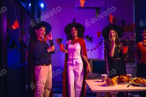 Preview: Asian friends, middle-aged man and young woman, enjoy Halloween office party with vampire costumes