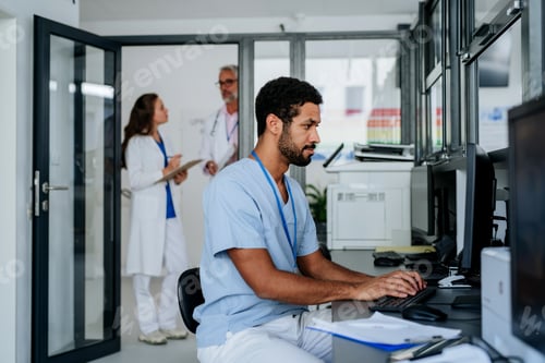 Preview: Young doctor working on computer in his office.