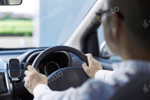 Preview: Back view of an elderly person driving a car