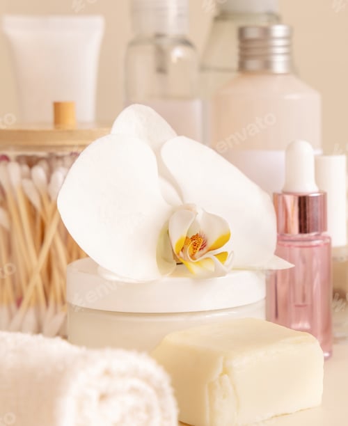 Preview: Natural cosmetic jars and skin care accesories with white orchid flower on beige close up