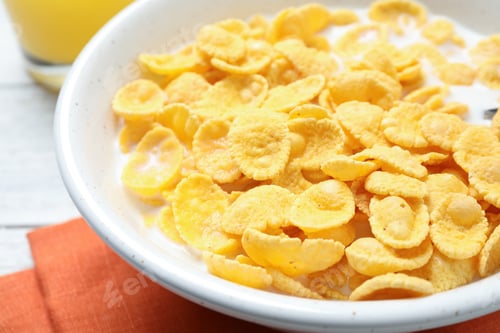 Preview: Tasty corn flakes with milk on white table, closeup