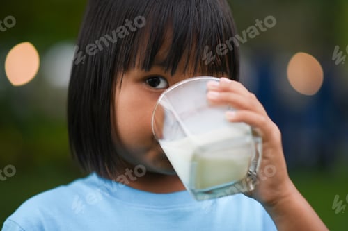 Preview: Little girl drinking milk in the park