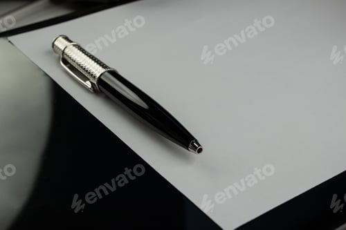 Preview: Closeup of a black ball pen on a white table