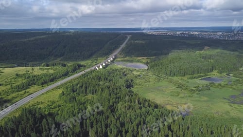 Preview: Top view of bridge passing through in forest. Clip. Highway passes through swamp in forest to city
