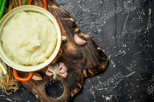 Preview: Mashed potatoes in a bowl with green onions and garlic .