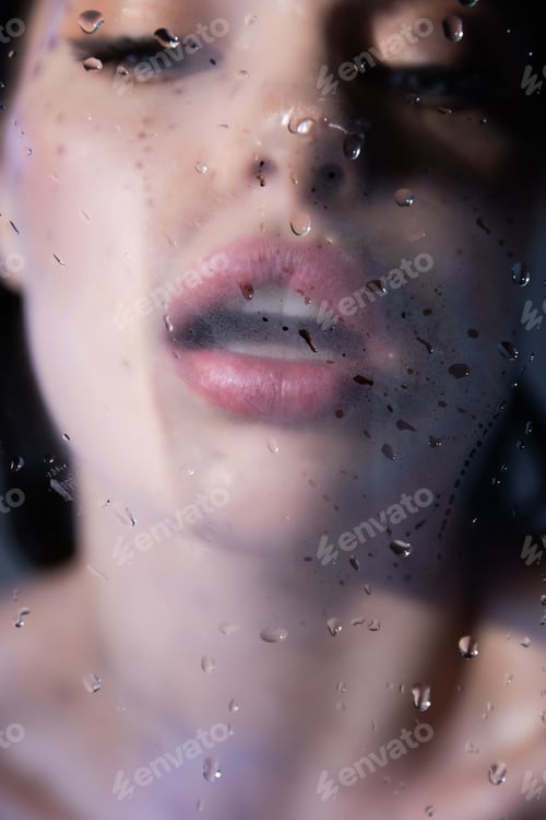 Preview: Blurred woman breathing on wet glass on grey background