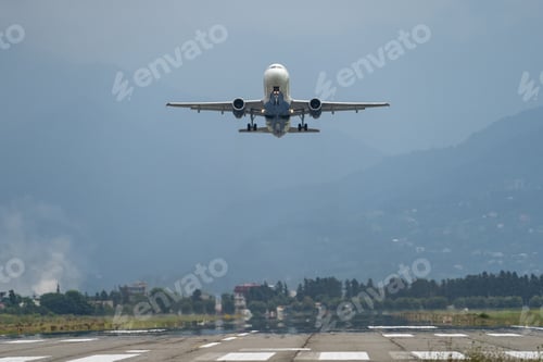 Preview: Airplane taking off from the airport, mountains on background. Transportation concept