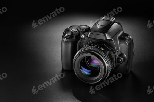 Vista previa: Black DSLR camera with mounted lens on a dark matte surface.