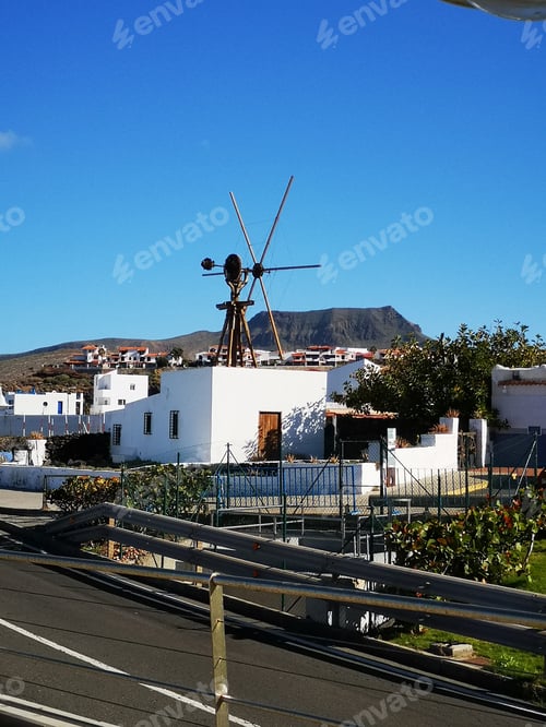 Preview: Vertical shot of a wooden windmill on a blue sky background