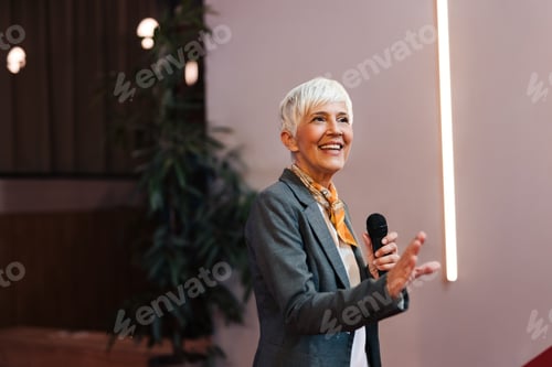 Preview: Happy senior woman talking about some company projects, having a speech.
