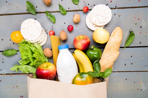 Preview: Grocery shopping concept. Different food in paper bag on wooden background. Flat lay.