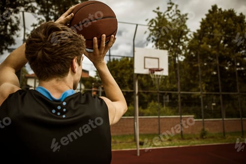 Preview: Young basketball player aiming for basketball hoop, back view