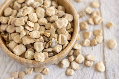 Preview: Bowl of raw dry Grass pea close up on wooden table. Legumes known in Italy as Cicerchia