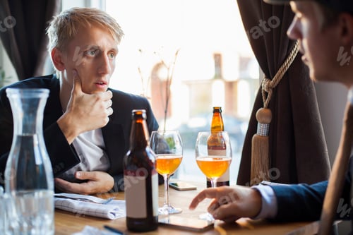 Preview: Worried man listening to gay partner in restaurant