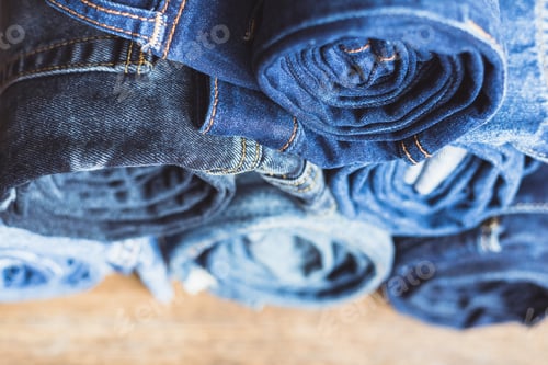 Preview: Jeans stacked on a wooden background