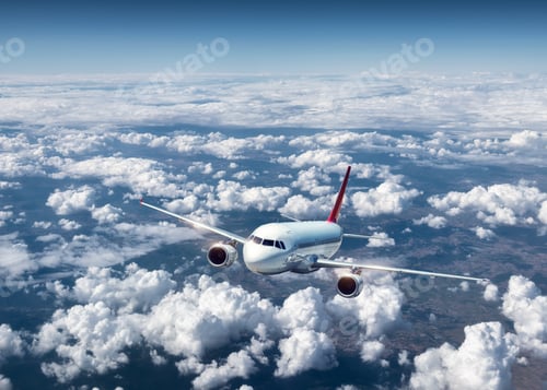 Preview: Airplane is flying above the clouds at sunset in summer