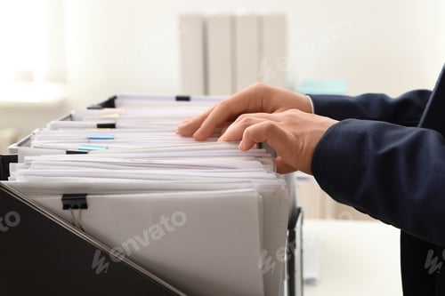 Preview: Woman taking documents from folder in archive, closeup