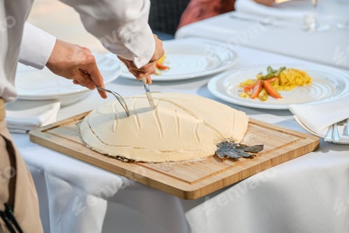 Preview: Crop waiter serving fish baked in salt crust