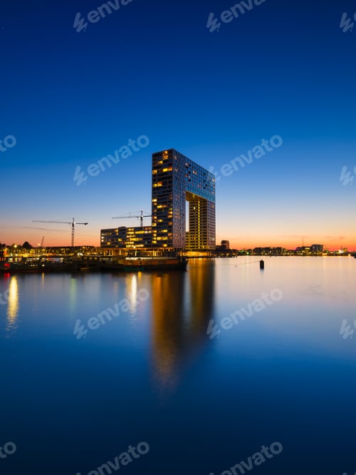 Preview: Amsterdam, Netherlands. A cityscape in the evening. A skyscraper and business center