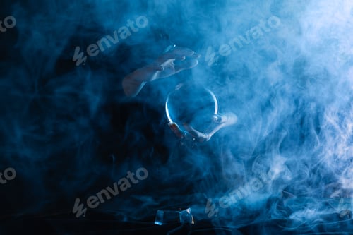Preview: Cropped view of witch holding crystal ball with smoke around on dark blue