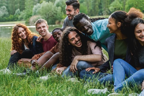Preview: Multiethnic happy group of people having fun outdoor by the lake - Focus on blond man face