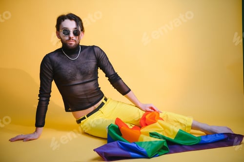 Preview: Young gay man is standing in the studio and posing for a camera.