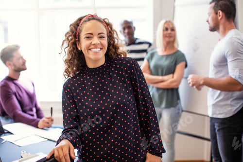 Preview: Smiling young designer standing in an office after a meeting