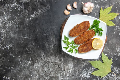 Preview: top view cutlets lemon slice parsley on white plate on wooden serving board garlic plane tree leaves