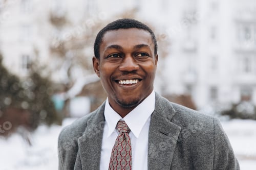 Preview: Happy African American businessman smiling outdoors in winter