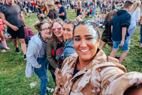 Preview: Selfie of a group of young women at musical festival with glitter