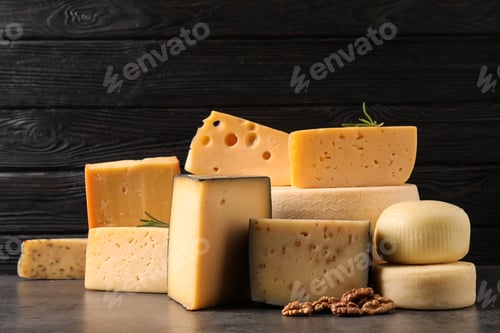 Preview: Different types of delicious cheese on table against wooden background