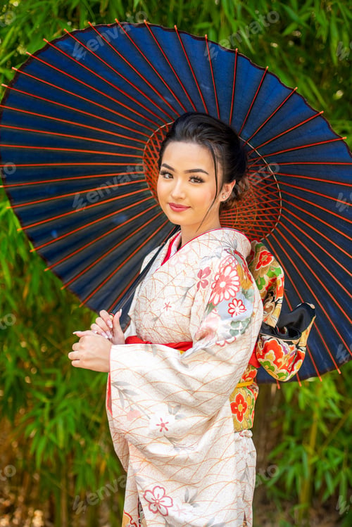 Preview: Elegance under the sun Young woman in a colorful kimono with a blue parasol