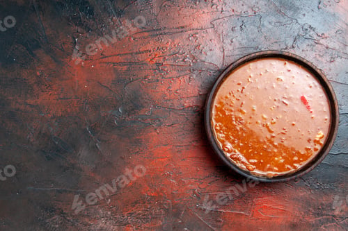 Preview: Top view of tomato soup in a brown bowl on mixed color background