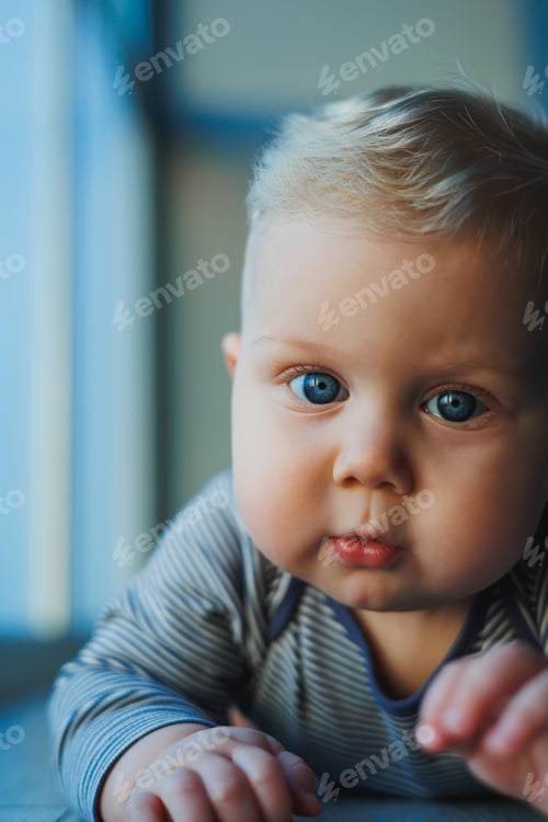 Preview: Happy smiling child. A cute little newborn baby boy with a smiling face is crawling on the floor